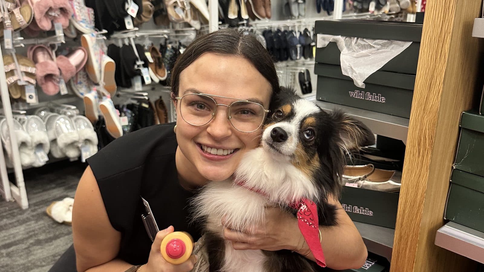 An owner smiling cheek to cheek with her mini australian shepherd